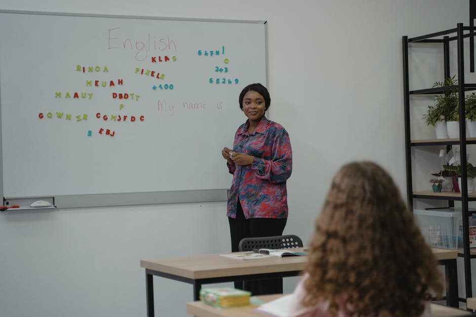 A teacher explaining English concepts to a student in a classroom setting with a whiteboard