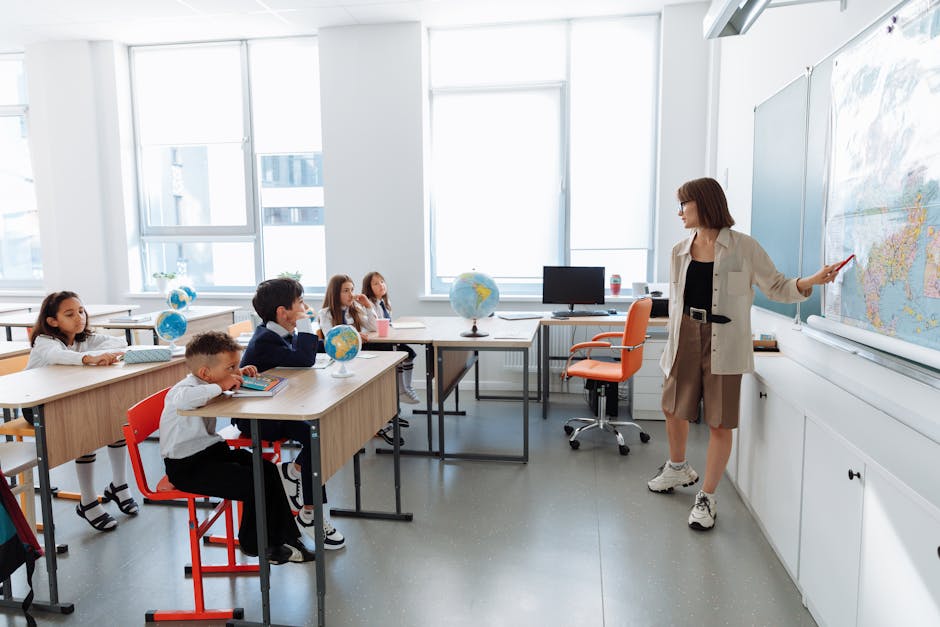 Children in a classroom learning about geography with a teacher using a map